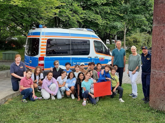 Grundschulklasse übergibt Spendenscheck an Wünschewagen Team Grundschulklasse übergibt Spendenscheck an Wünschewagen Team