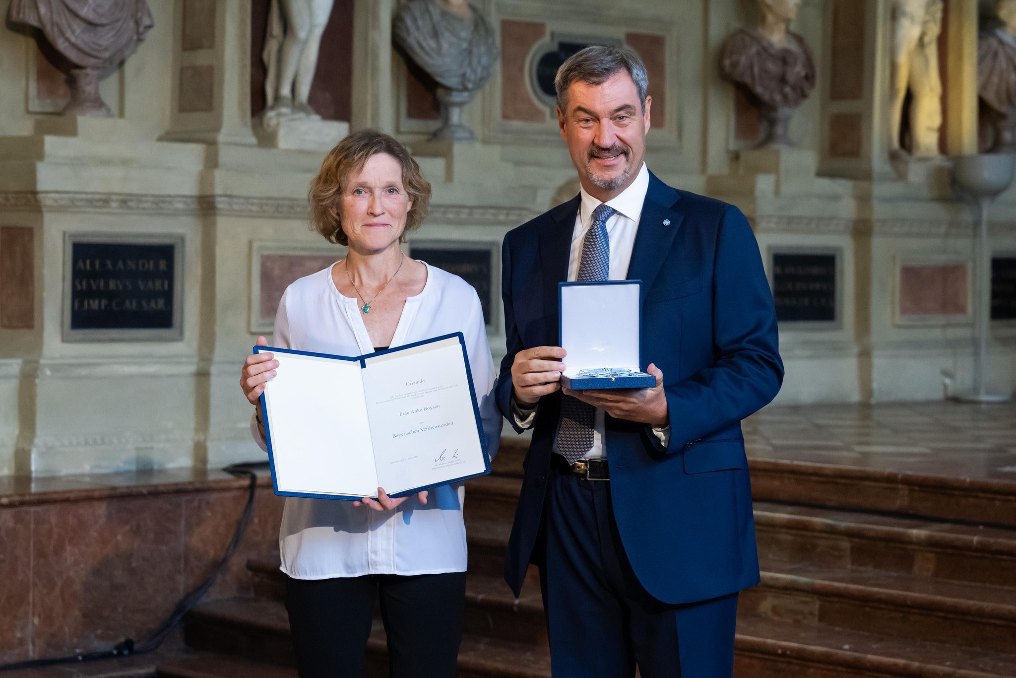 Anke Boysen mit Ministerpräsident Markus Söder und der Urkunde des Bayerischen Verdienstorden